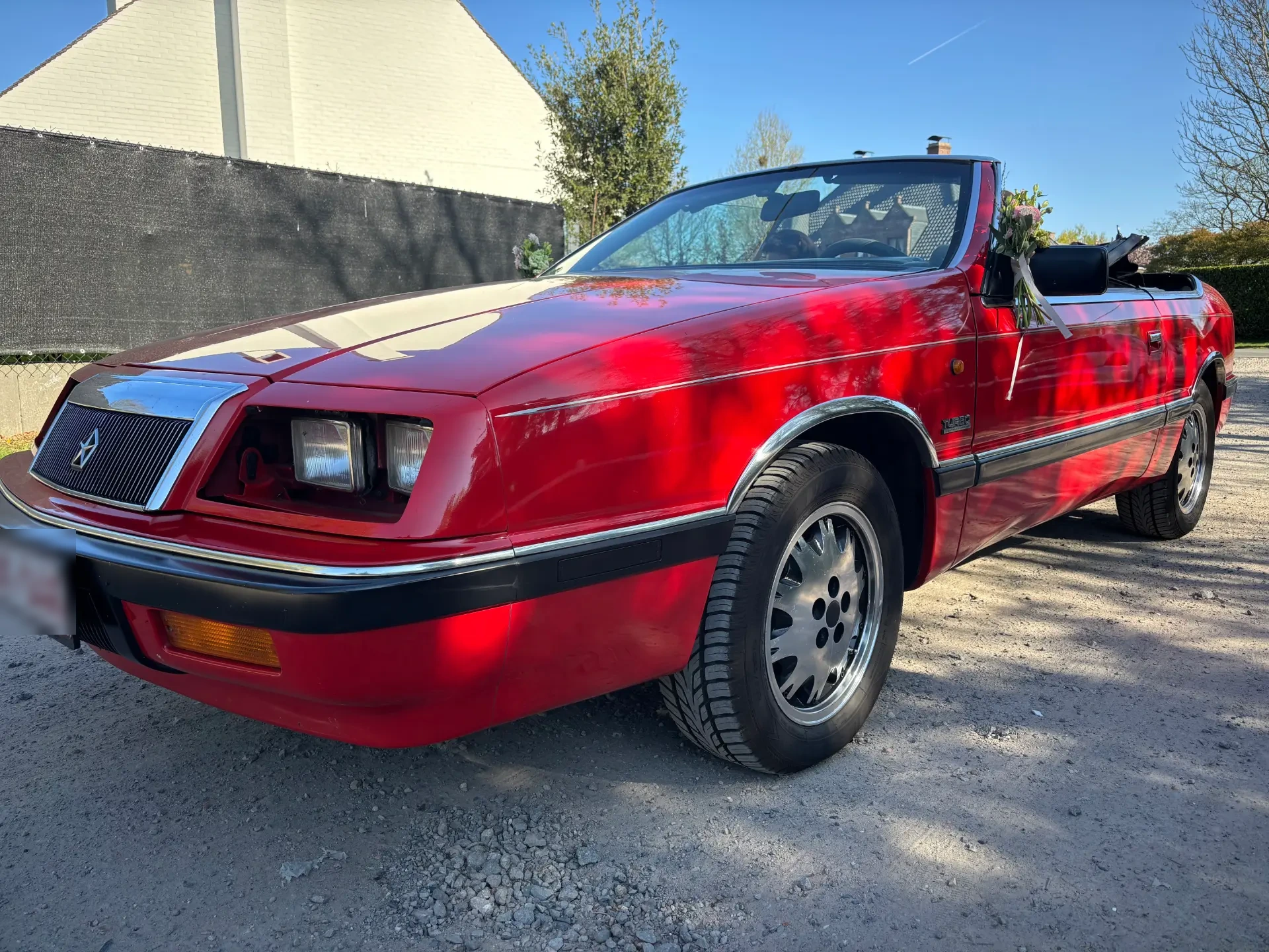 Vooraanzicht van de rode Chrysler Le Baron Turbo cabrio